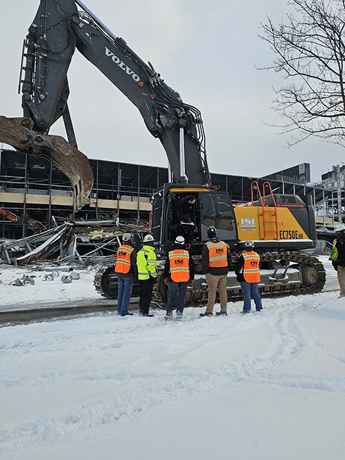 Part of the demolition team near an excavator