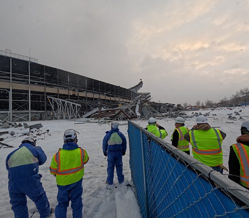 Members of different construction and demolition teams walking the construction site together