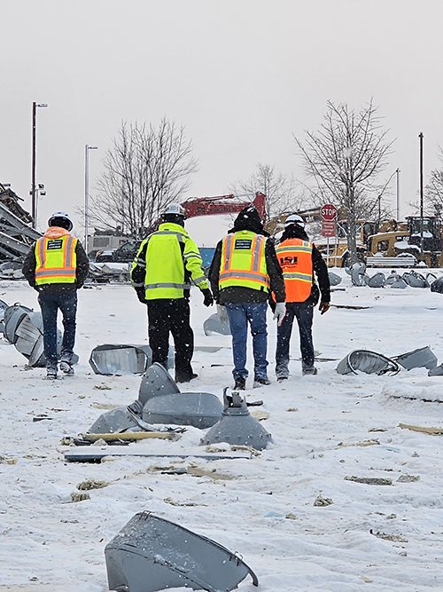 Members of different construction and demolition teams walking the construction site together