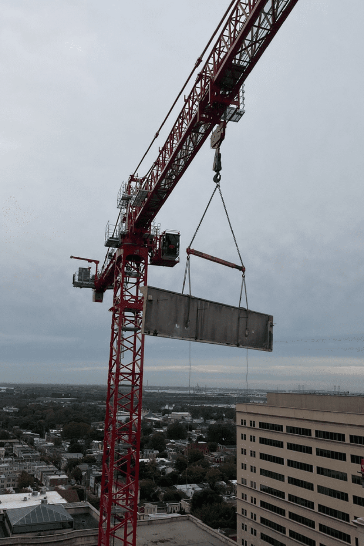Crane lifting concrete material off the building during demolition