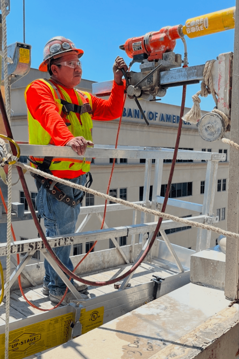 Construction worker using a core drill during demolition
