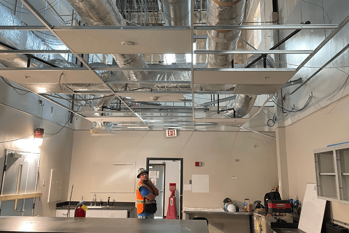 A crew member inspecting the ceiling during to demolition. 