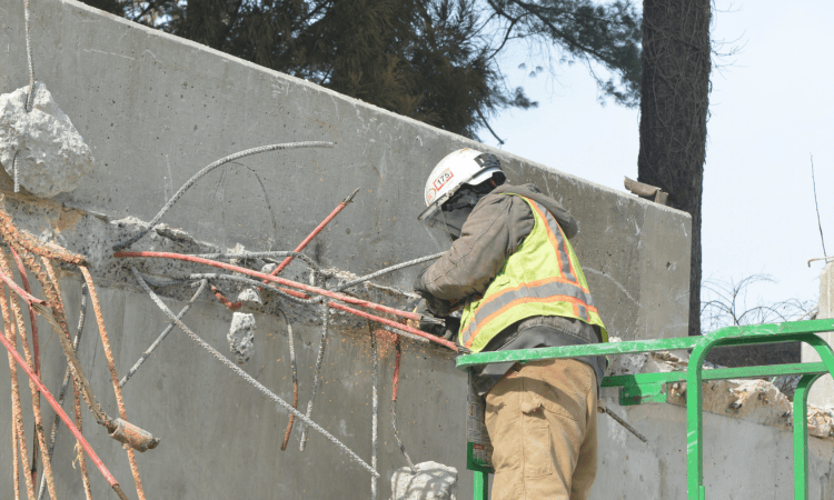 Demolition crews detensioning post-tension concrete